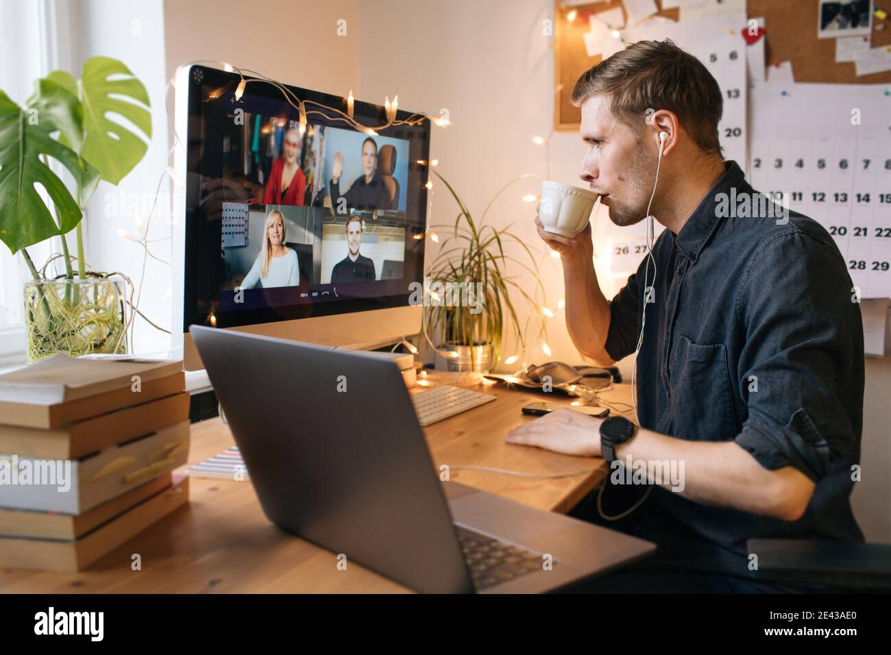 Morning coffee break during work from home. Man working on computer in office. Video conference screen remote call. Business internet telework. Stock Photo