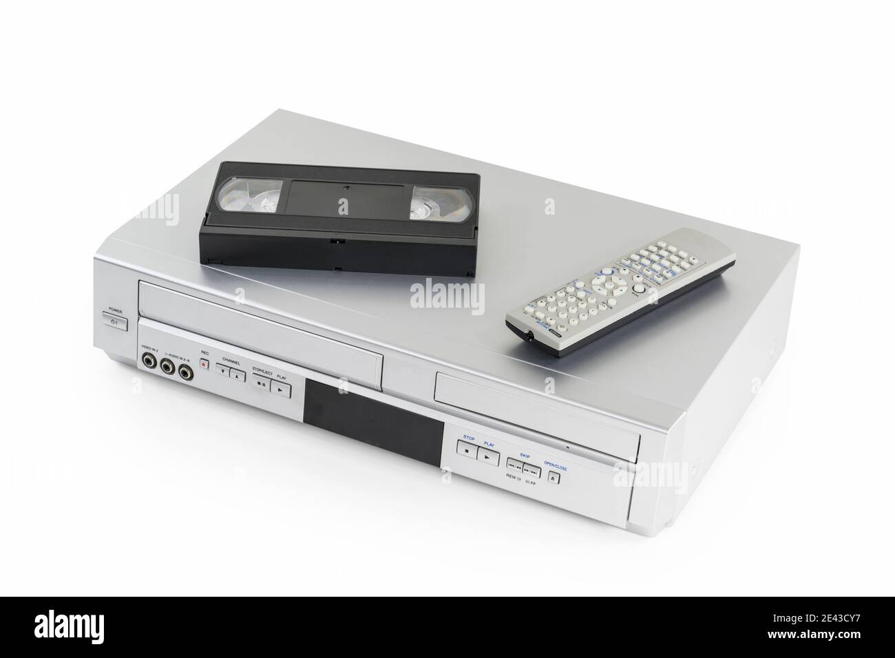 Old video cassette and disk player with tape and remote controller on white. Stock Photo