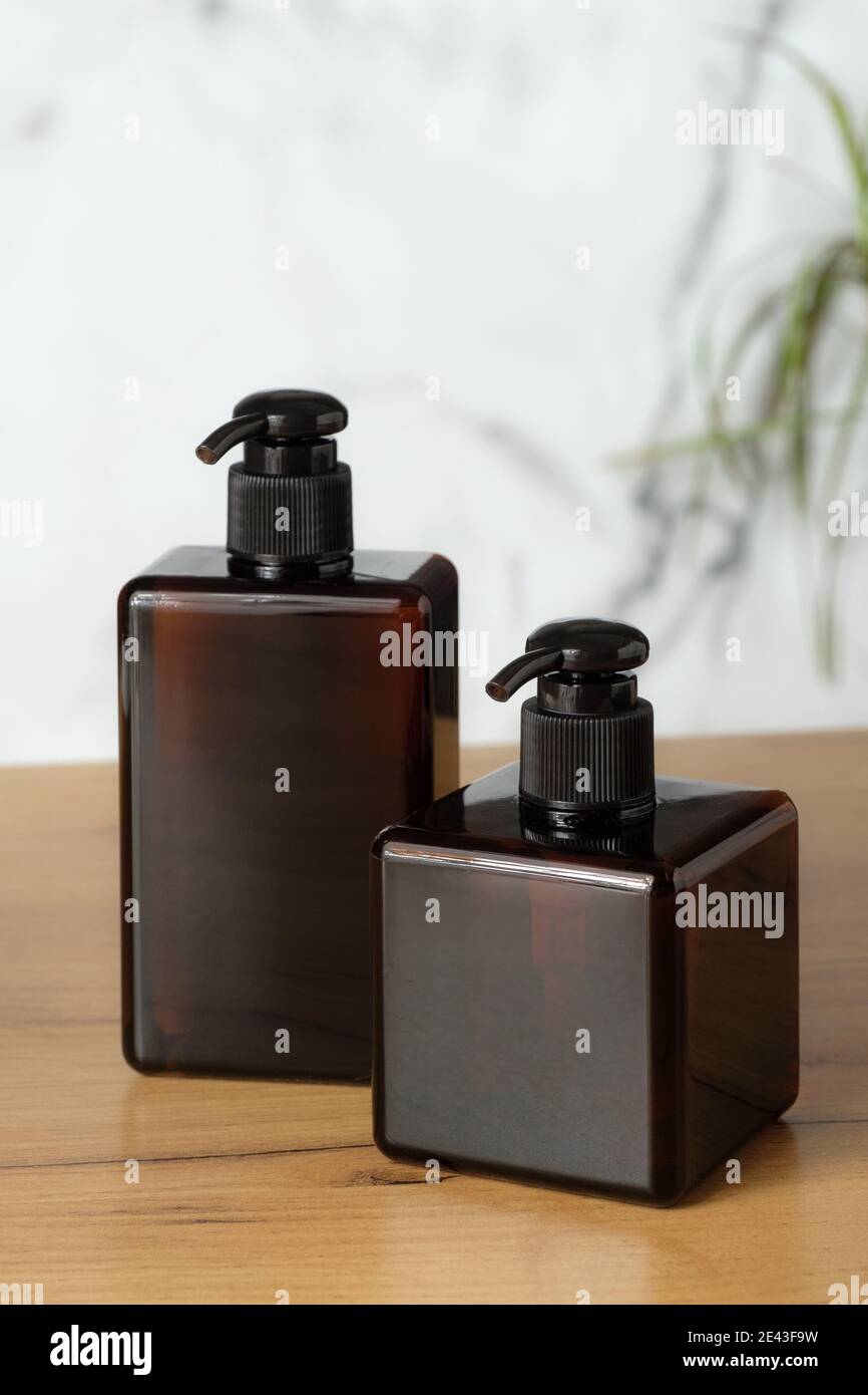 Set of amber glass bottles for shampoo or soap. Pump dispenser bottles