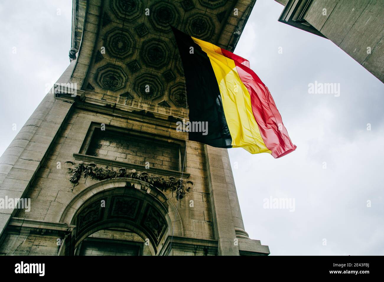 Low angle shot of the Belgium flag under the Arcade du Cinquantenaire Stock Photo
