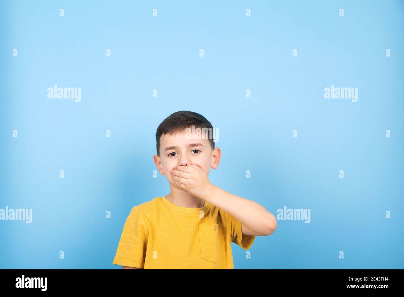 Surprised little boy covered his mouth with his hand Stock Photo