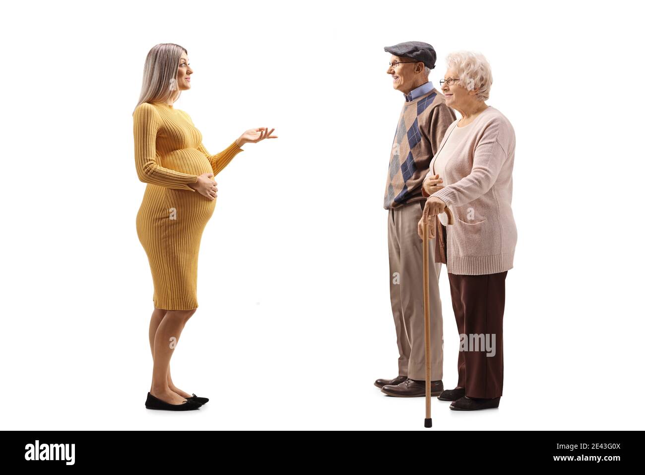 Full length profile shot of a pregnant woman talking to an elderly man and woman isolated on white background Stock Photo