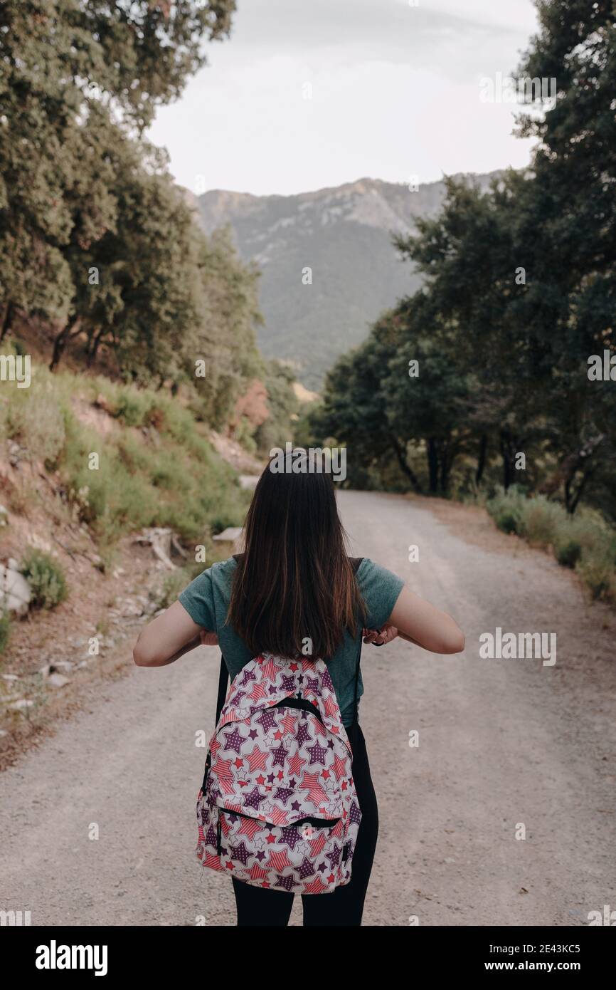 Full body back view of unrecognizable female hiker with backpack ...