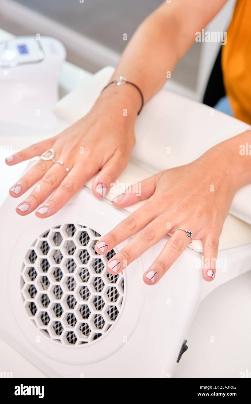 Crop anonymous female client keeping palms on hand rest stand during ...