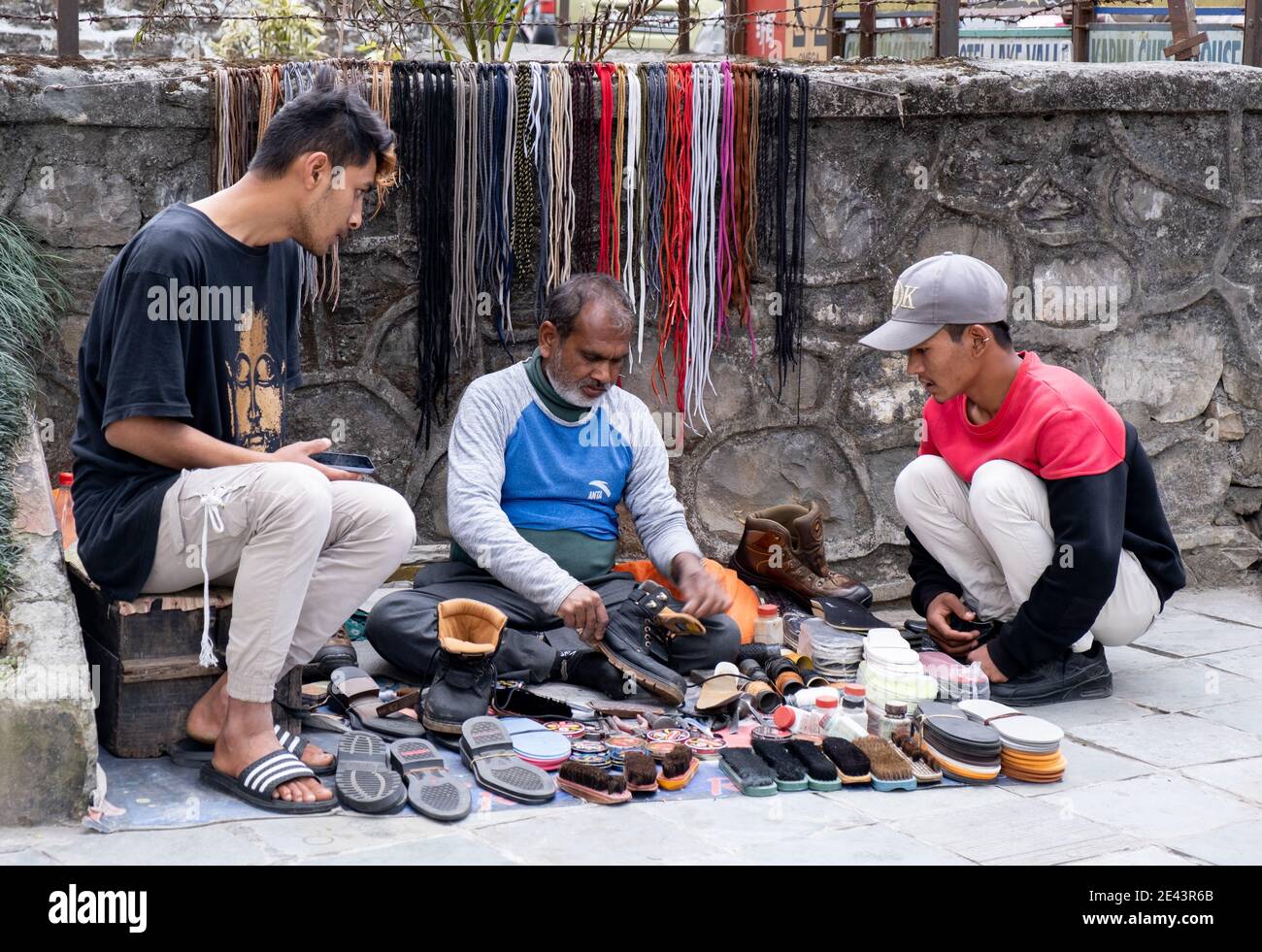 Man fixing and cleaning shoes in the streets of Pokhara, Nepal Asia.  Working in the street Stock Photo - Alamy