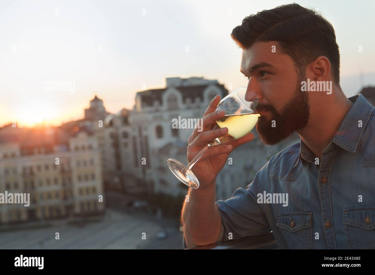 Close up of a bearded man sipping wine outdoors on sunset Stock Photo