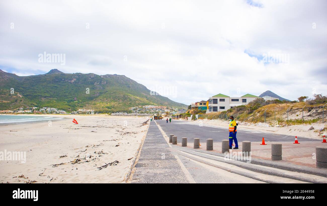 Hout Bay- Cape Town, South Africa - 19-01-2021 Long cement parking lot closed due to lockdown. Security guard wearing face mask in foreground. Stock Photo
