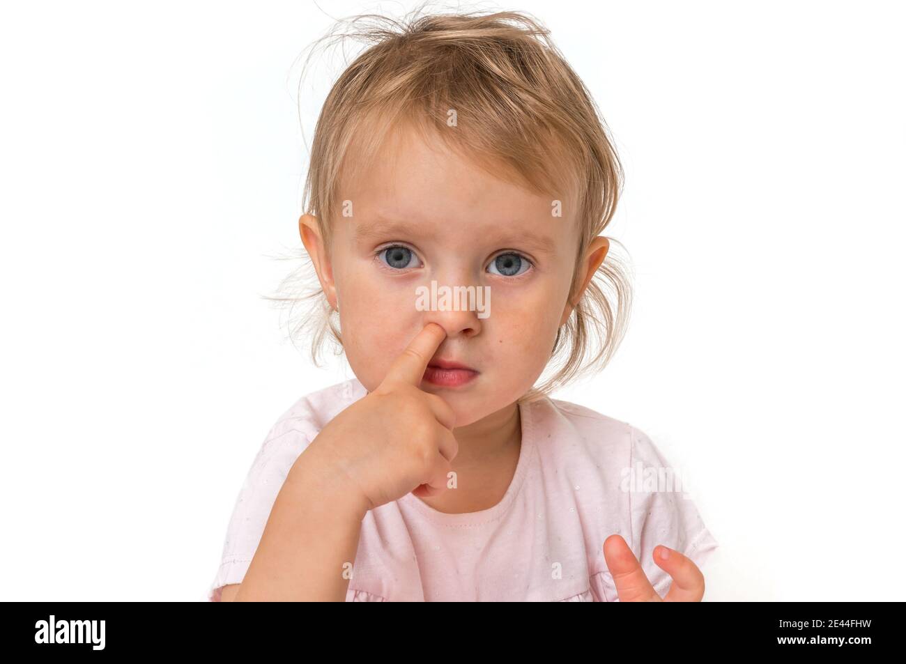 Baby girl is picking her nose with finger inside hygiene concept
