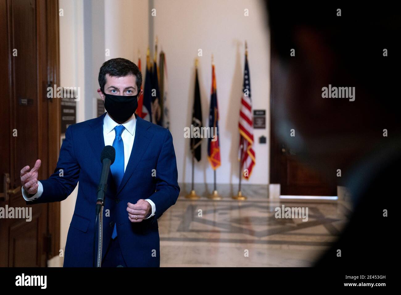 Pete Buttigieg, U.S. secretary of transportation nominee for U.S. President Joe Biden, wears a protective mask while speaking to members of the media after a Senate Commerce, Science and Transportation Committee confirmation hearing in Washington, DC, U.S., on Thursday, Jan. 21, 2021. Buttigieg, is pledging to carry out the administration's ambitious agenda to rebuild the nation's infrastructure, calling it a 'generational opportunity' to create new jobs, fight economic inequality and stem climate change. Credit: Stefani Reynolds/Pool via CNP | usage worldwide Stock Photo