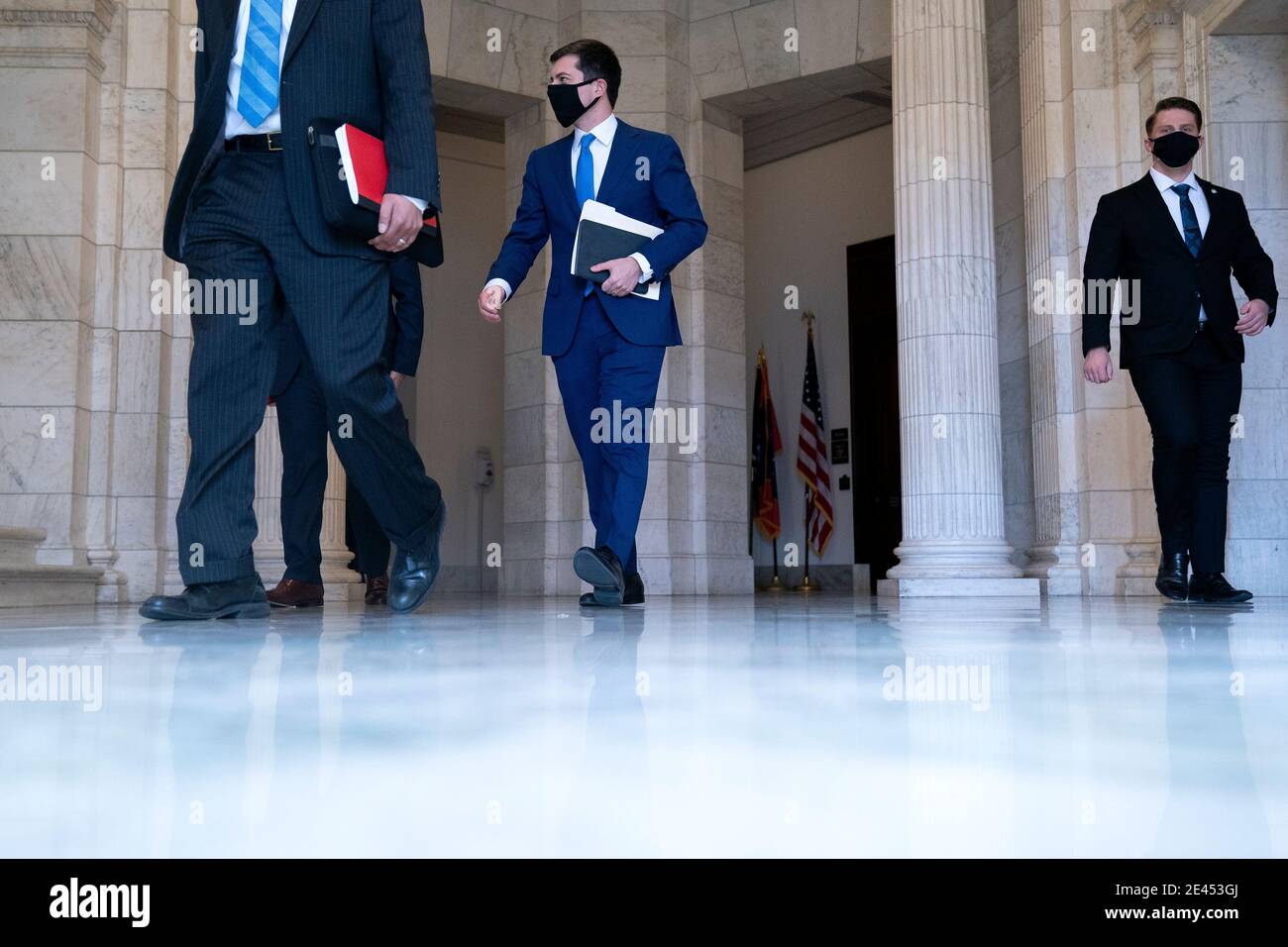 Pete Buttigieg, U.S. secretary of transportation nominee for U.S. President Joe Biden, center, wears a protective mask while departing after a Senate Commerce, Science and Transportation Committee confirmation hearing in Washington, DC, U.S., on Thursday, Jan. 21, 2021. Buttigieg, is pledging to carry out the administration's ambitious agenda to rebuild the nation's infrastructure, calling it a 'generational opportunity' to create new jobs, fight economic inequality and stem climate change. Credit: Stefani Reynolds/Pool via CNP | usage worldwide Stock Photo