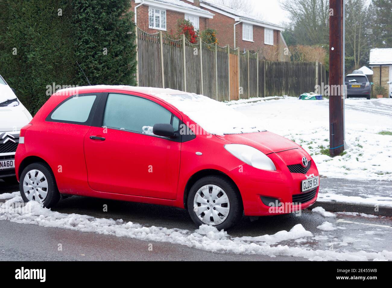 red toyota prius covered in snow parked on road side London Stock Photo