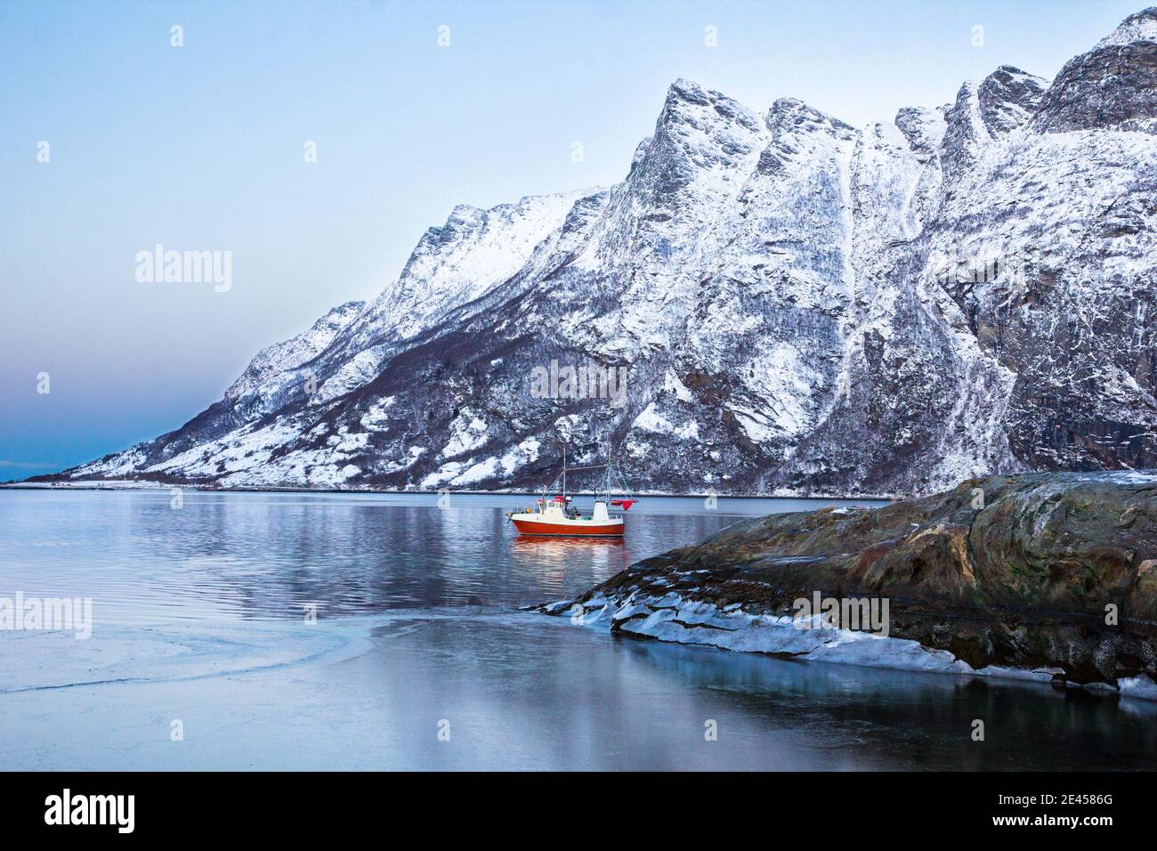 A small Norwegian fishing boat is nestled in a fjord. Stock Photo