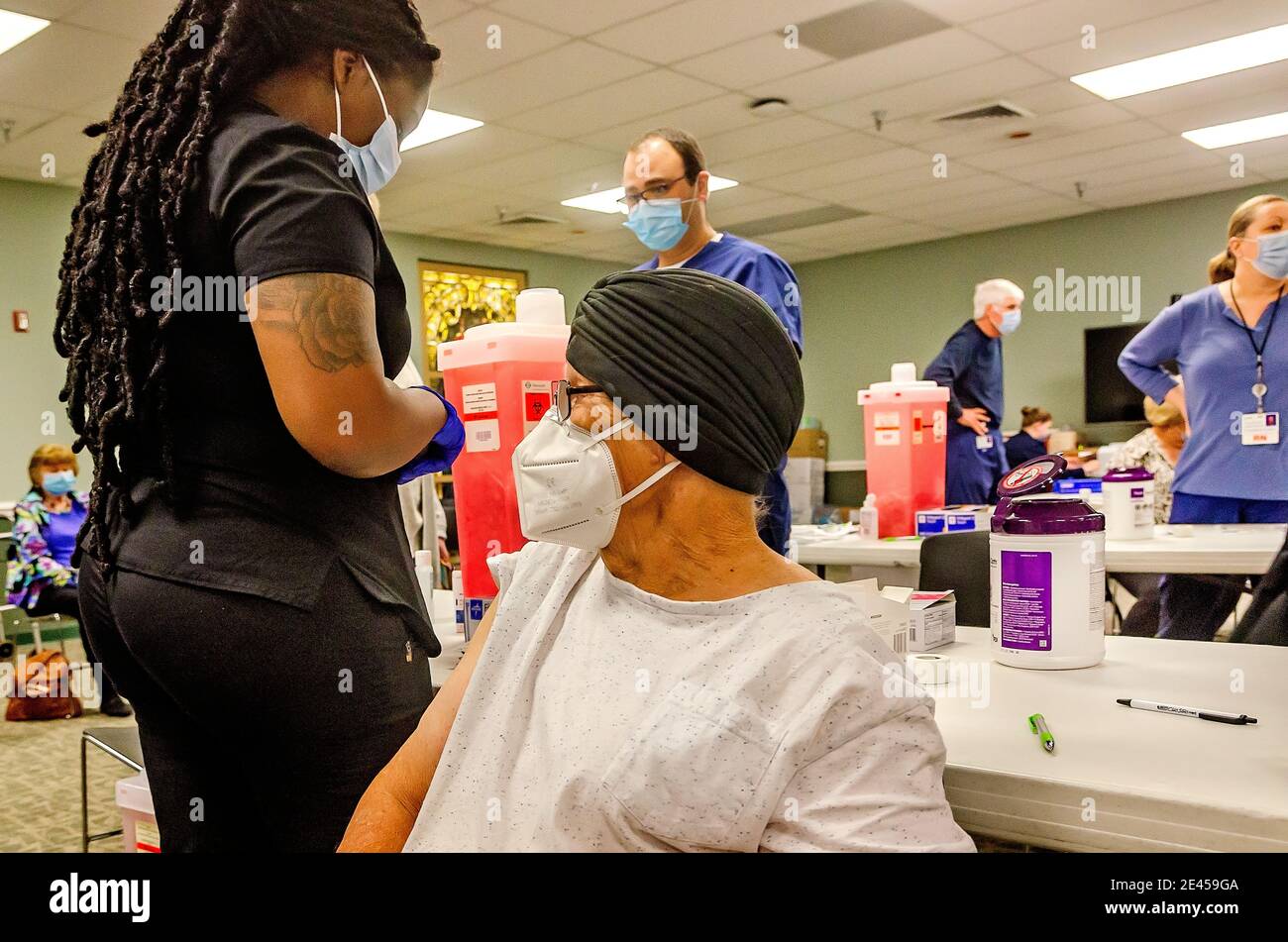 A senior citizen waits while a healthcare worker prepares to administer the first dose of the COVID-19 vaccine from Pfizer-BioNTech in Mobile, Alabama. Stock Photo