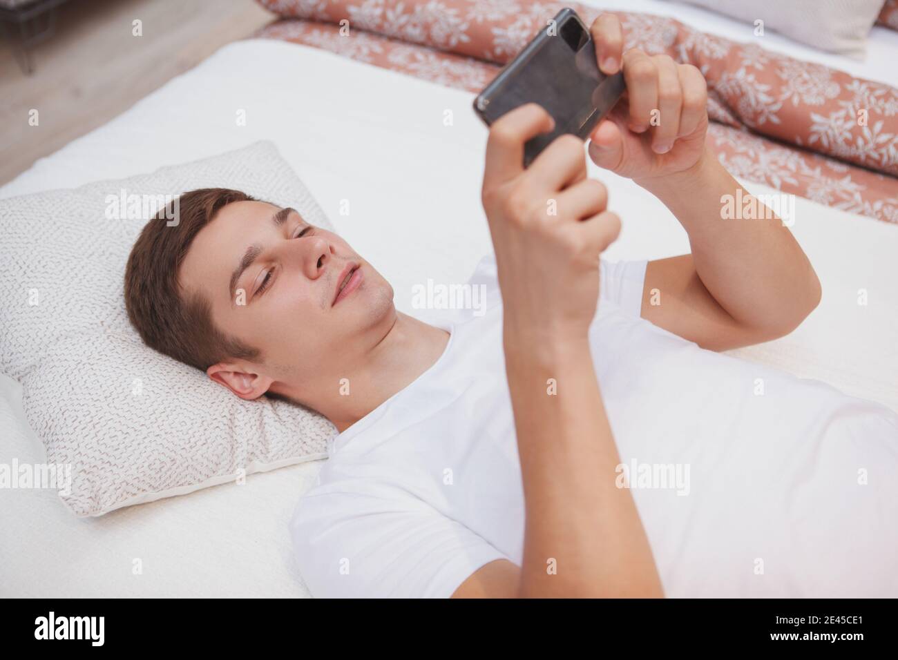 Приковала парня кровать. Ленивый парень на кровати с телефоном играет. Ленивый парень на кровати с телефоном играет в ээегри Бердс.