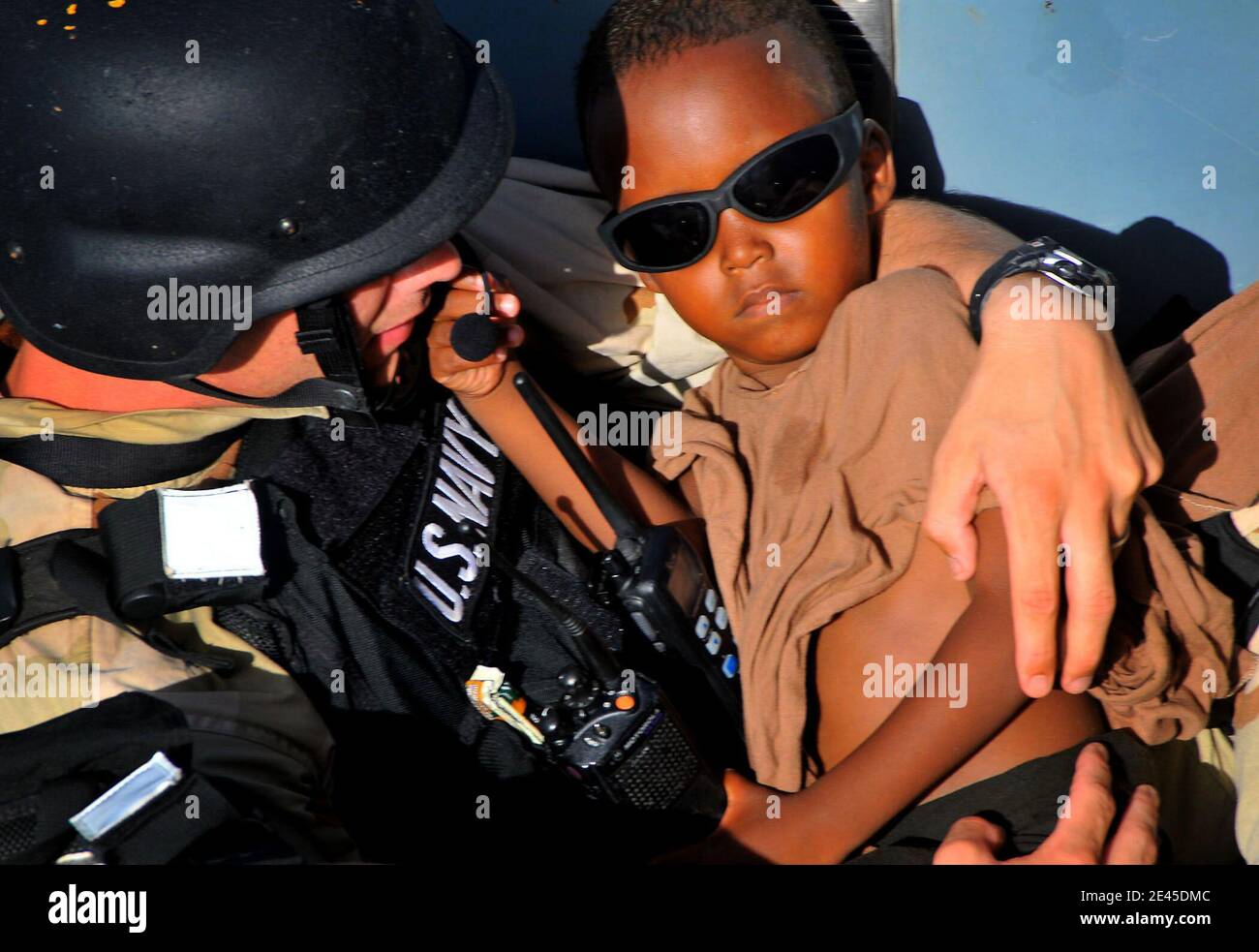 A member of the visit, board, search, and seizure team carries a five-year-old Somali migrant to the guided-missile cruiser USS Lake Champlain after being rescued from a disabled skiff in the Gulf of Aden on May 24, 2009. The skiff, originally ferrying 52 passengers, was spotted in distress by Lake Champlain helicopter pilots while patrolling the area. Photo by Daniel Barker/USN via ABACAPRESS.COM Stock Photo