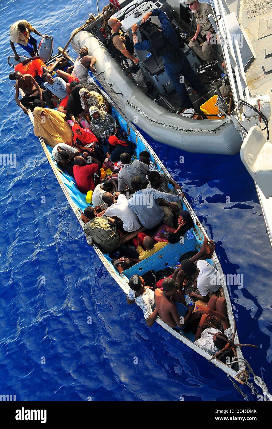 Somali migrants in a disabled skiff receive assistance from Sailors aboard the guided-missile cruiser USS Lake Champlain in the Gulf of Aden on May 24, 2009. The skiff, originally ferrying 52 passengers, was spotted in distress by Lake Champlain helicopter pilots while patrolling the area. Photo by Daniel Barker/USN via ABACAPRESS.COM Stock Photo