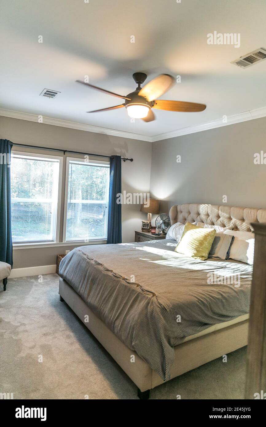 Spacious beige carpeted master bedroom with king sized bed Stock Photo