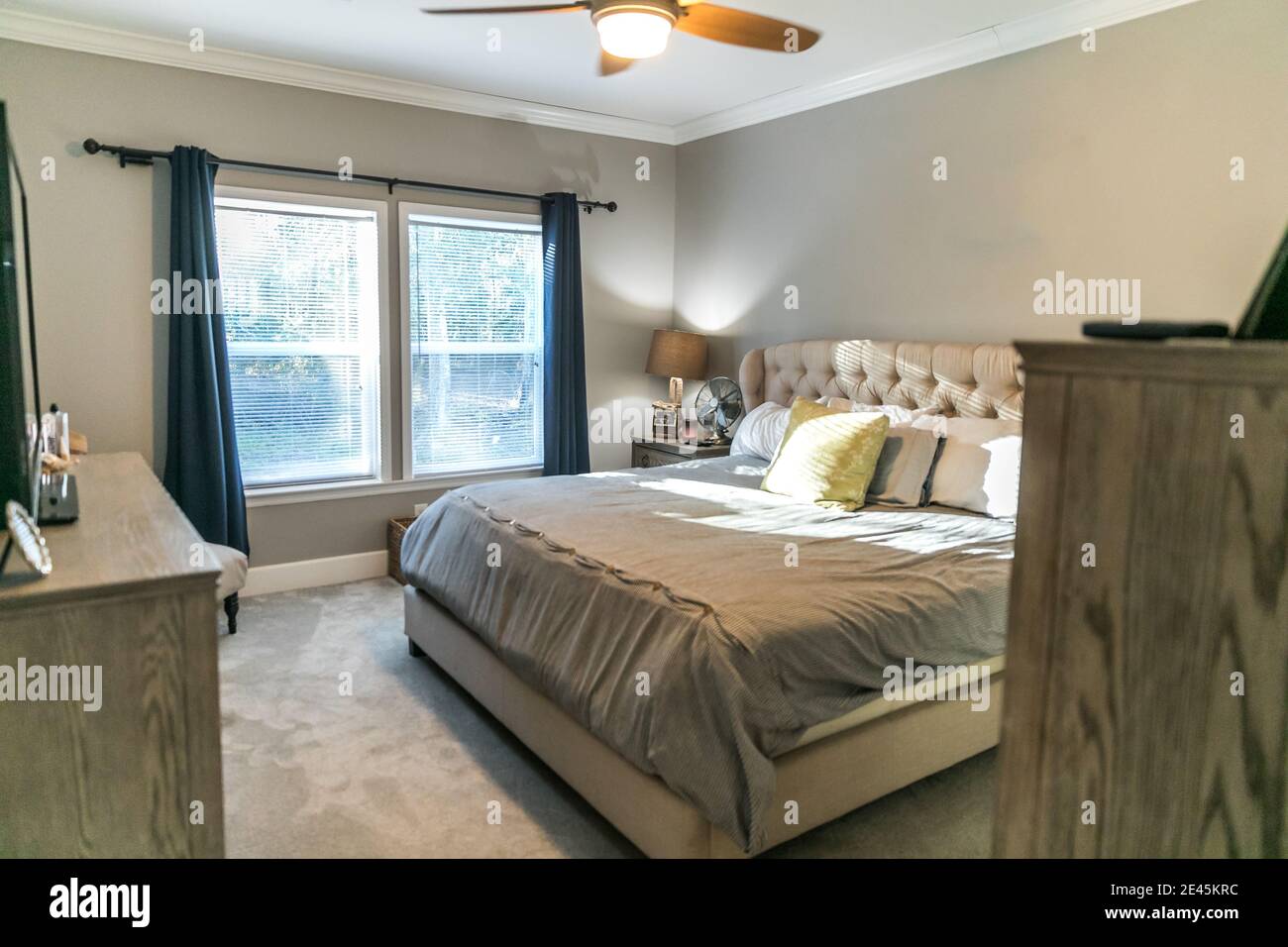Spacious beige carpeted master bedroom with king sized bed Stock Photo