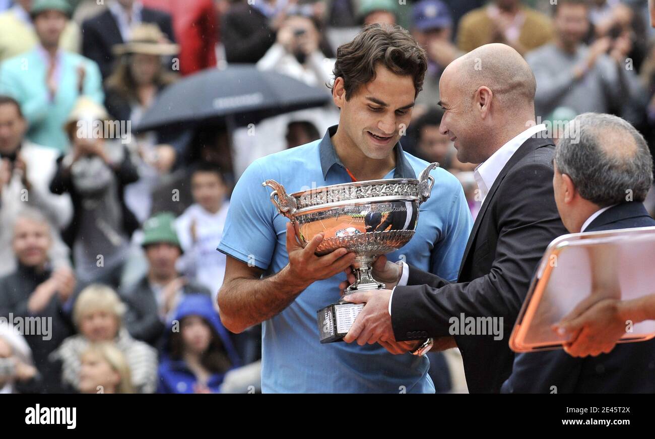 Switzerland's Roger Federer receives the trophy from US former tennis player Andre Agassi following his victory during the men's singles final match of the French Open tennis tournament at the Roland Garros stadium in Paris, Sunday June 7, 2009. The victory gives Federer 14 Grand Slams, tying his career wins to American Pete Sampras. Federer won 6-1, 7-6 (7/1), 6-4. Photo by Christophe Guibbaud/Cameleon/ABACAPRESS.COM Stock Photo