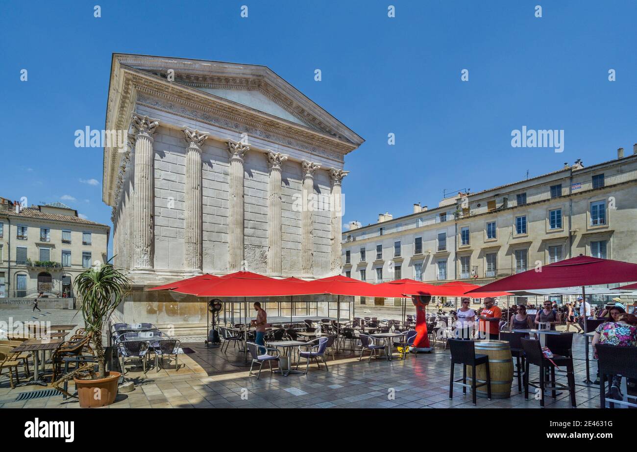 bars and restaurants on the south side of Maison Carrée, the ancient Roman temple in Nîmes is one of the best preserved Roman temples to survive in th Stock Photo