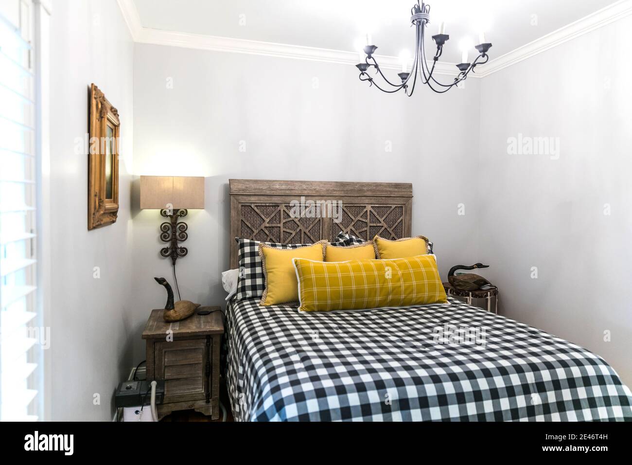 Small Guest Room With An Intricate Wood Bed Stock Photo Alamy