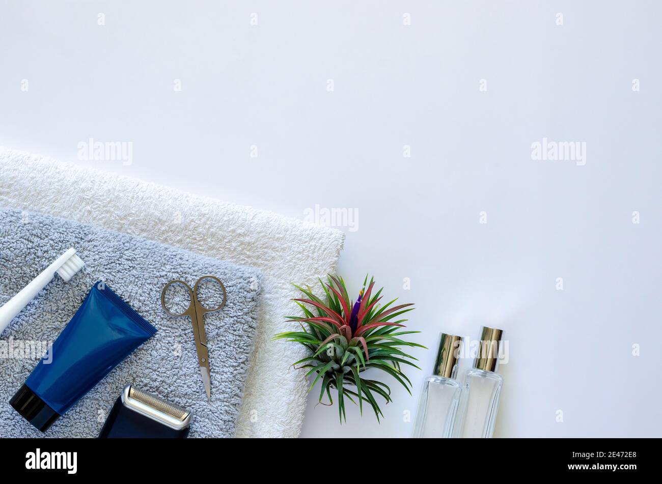 Men toiletries in modern lifestyle on towels with air plant Tillandsia on white background. Stock Photo