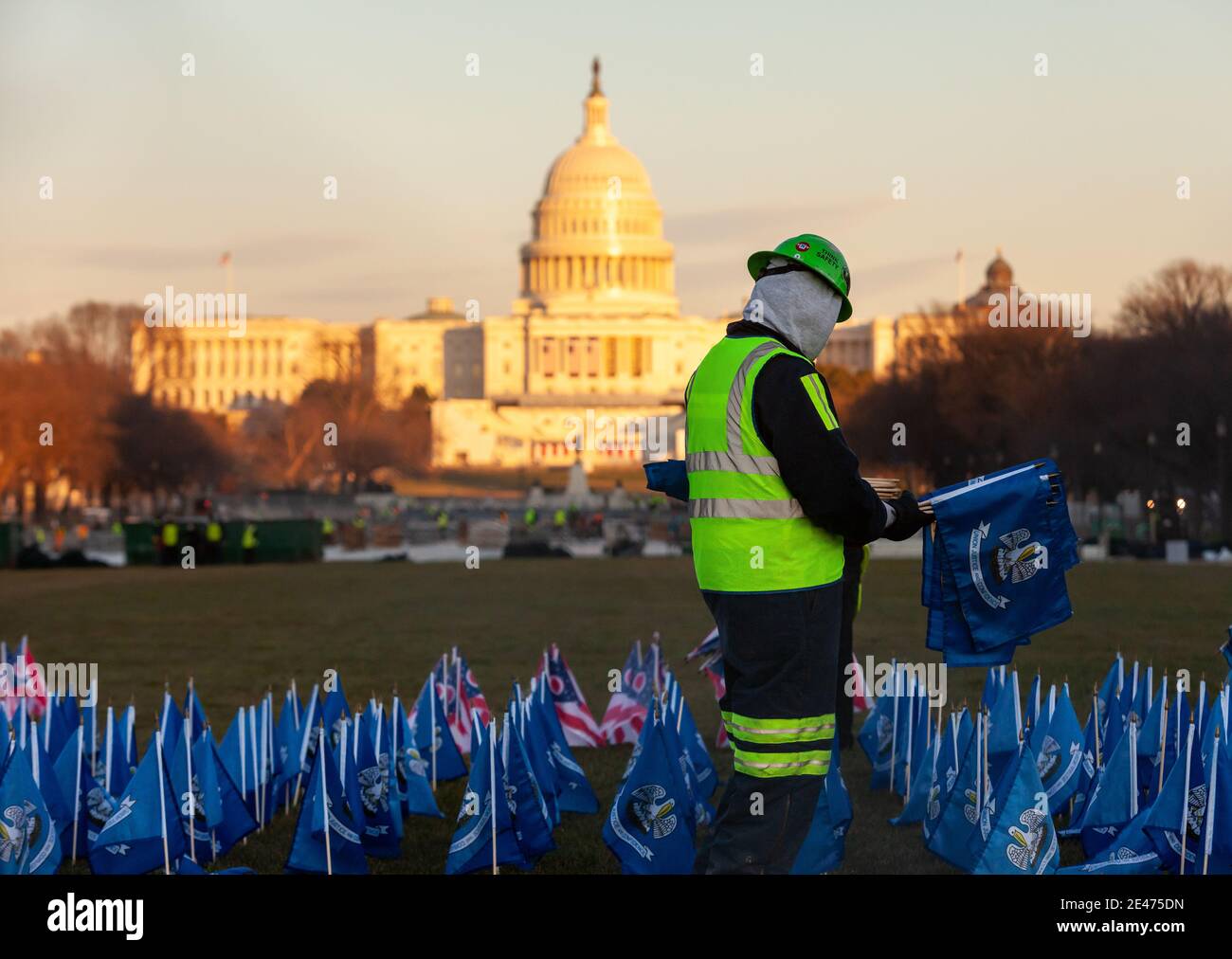 Washington, DC, USA, 21 January, 2021.  Pictured:  A worker clears the last of the flags from the Field of Flags on the National Mall, in front of the Capitol.  The day after a presidential inauguration mostly restores normaility to Washington.  Most of the extra security measures were gone and most roads had reopened by morning.  Credit: Allison C Bailey/Alamy Live News Stock Photo
