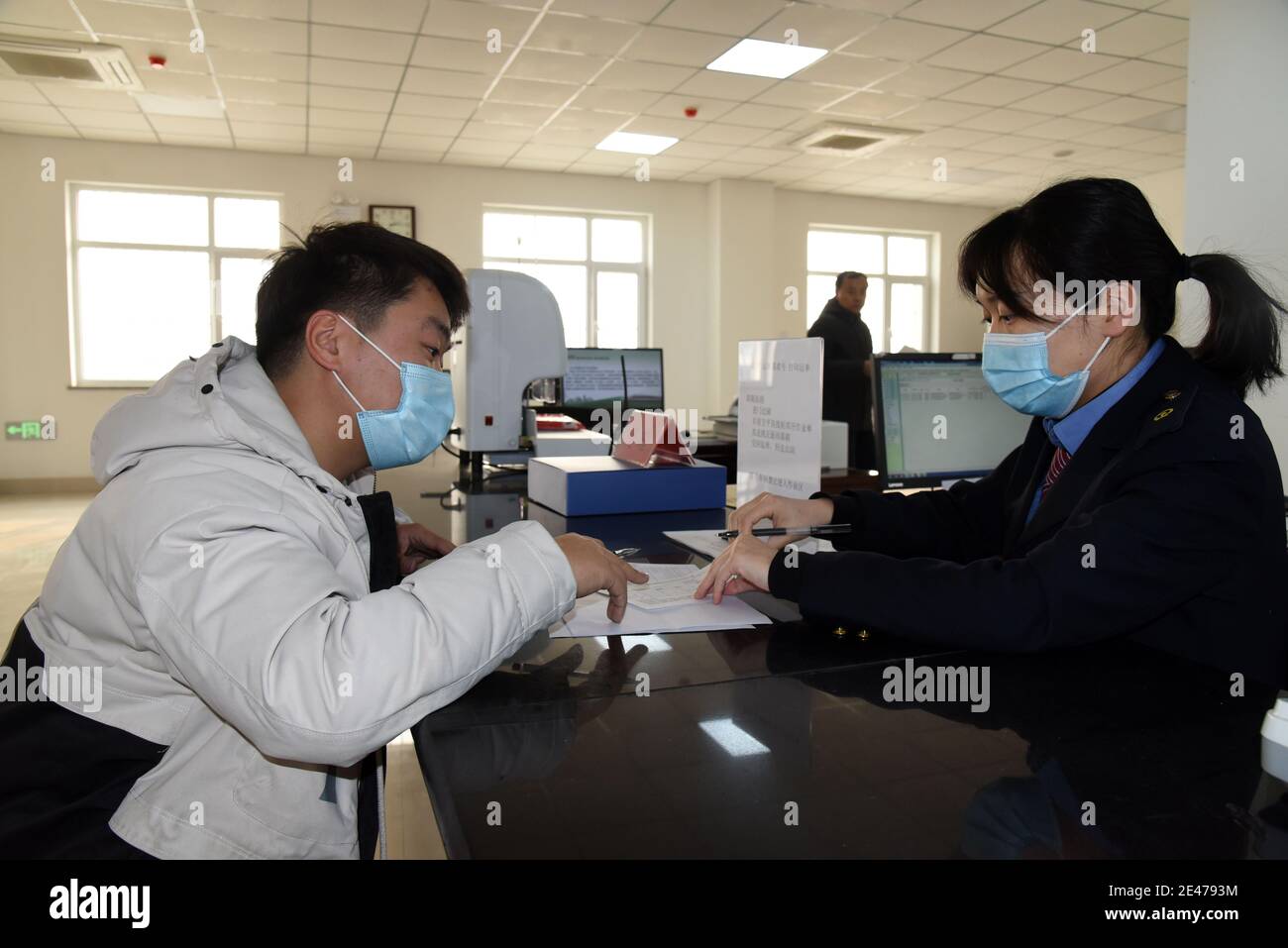 (210122) -- JINAN, Jan. 22, 2021 (Xinhua) -- A staff member (R) of the China Railway Jinan Group Co., Ltd. process consignment documents for a cargo owner in Dongjiazhen Township of Jinan City, capital of east China's Shandong Province, Jan. 21, 2021. The China Railway Jinan Group Co., Ltd. has been boosting the business of its 'Qilu' freight trains to Europe and other parts of Asia by steadily streamlining cargo flows in recent years. A total of 1,506 'Qilu' trains left Shandong in 2020, a year-on-year growth of 42.9 percent. These trains have served as 'accelerators' to Shandong's opening up Stock Photo