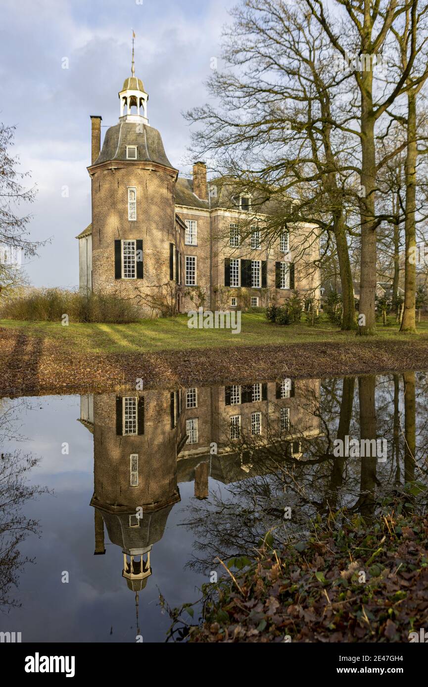 VORDEN, NETHERLANDS - Jan 08, 2021: Stately manor with stronghold tower of Hackfort castle partly obscured by winter barren trees Stock Photo