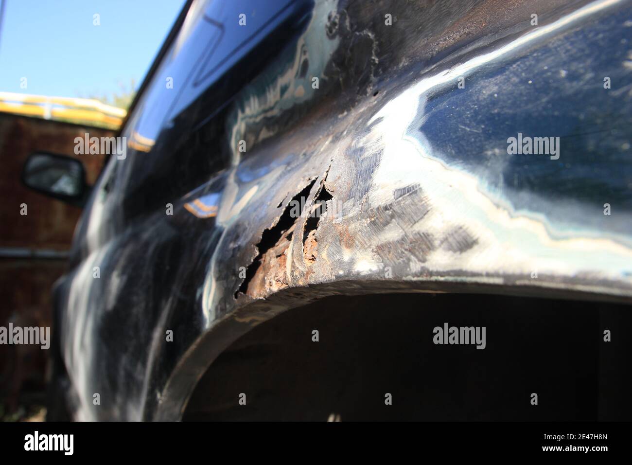 Metal corrosion on a car fender, rust hole. car body repair. Side view