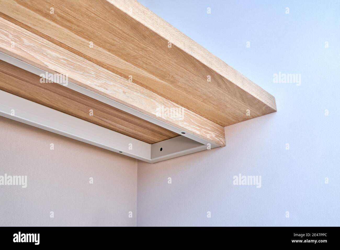 Elegant writing desk made with bleached solid oak timber mounted on white wall, bottom view Stock Photo