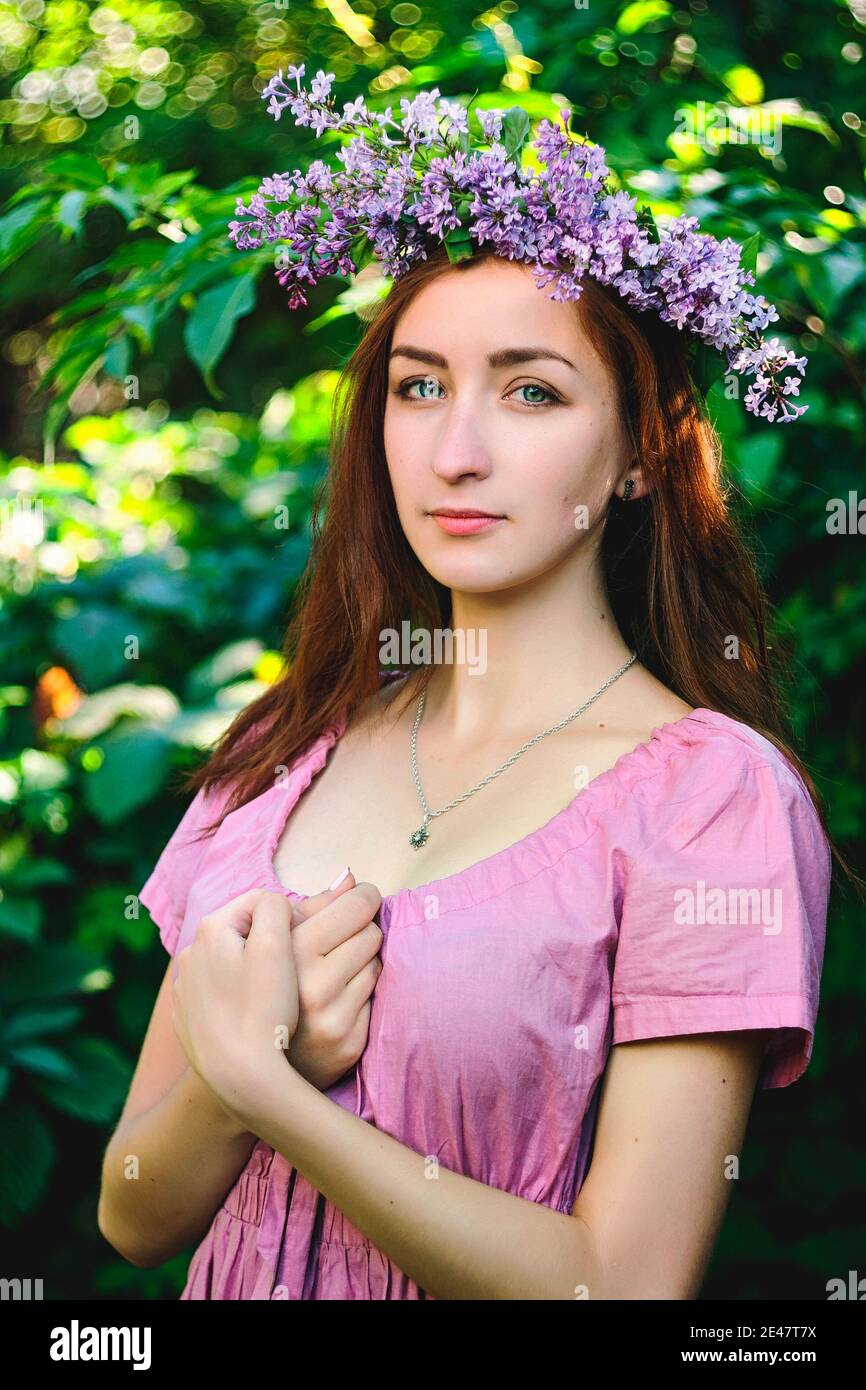 Portrait of young beautiful woman in pink dress in spring garden with ...
