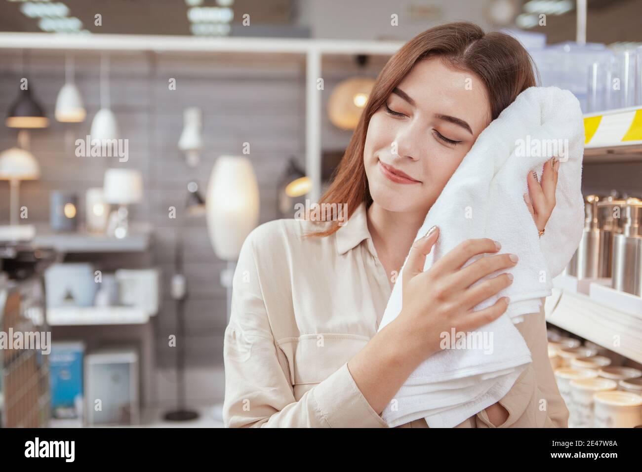 Charming woman buying soft towels for bathroom at local department