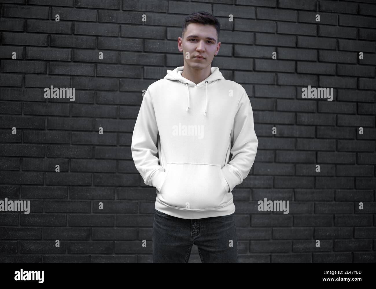 Mockup of a white hoodie with a pocket on a young guy in black jeans, front  view, long sleeve sweatshirt for presentation of design. Men's clothing te  Stock Photo - Alamy