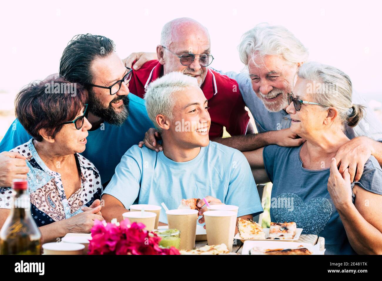 Group of cheerful friends family enjoy food and lunch celebration together with fun and friendship - concept of different ages years old people from t Stock Photo