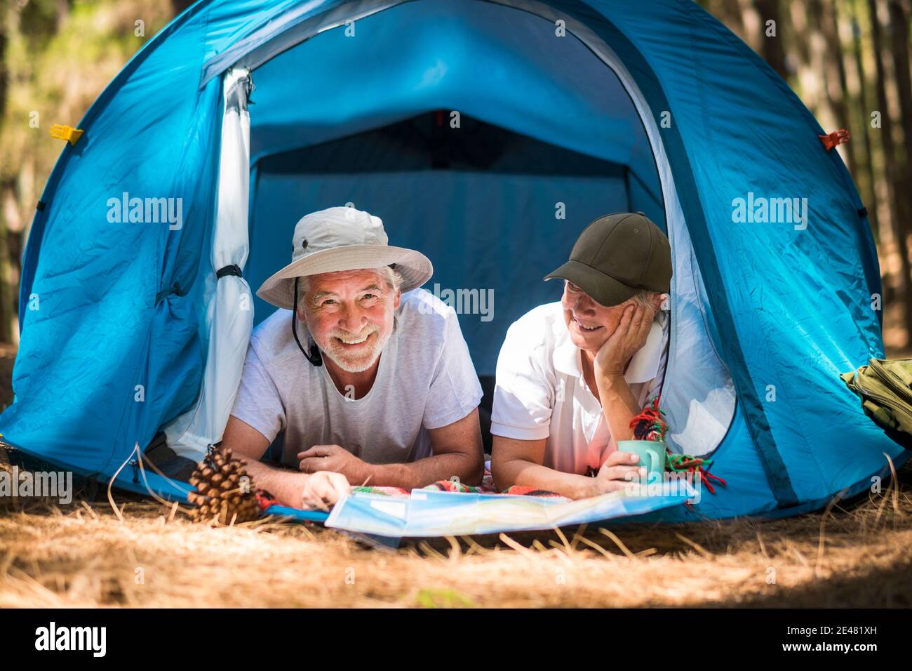 Active lifestyle old senior couple enjoy tent camping in the woods