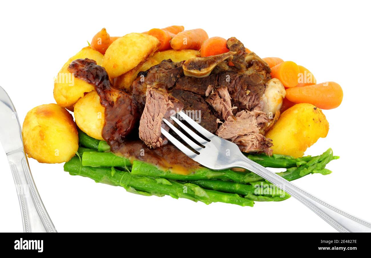Slow cooked lamb rump joint meal with roast potatoes, baby carrots and