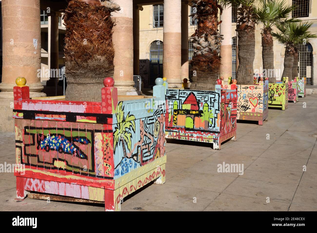 Colourful Wooden Planters Decorated with Grafitti Designs in front of the Columns of the Halle Puget Market Building (1672) Marseille France Stock Photo