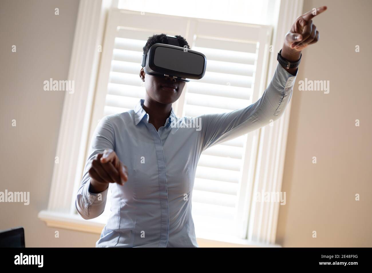 African american woman using vr headset in kitchen Stock Photo