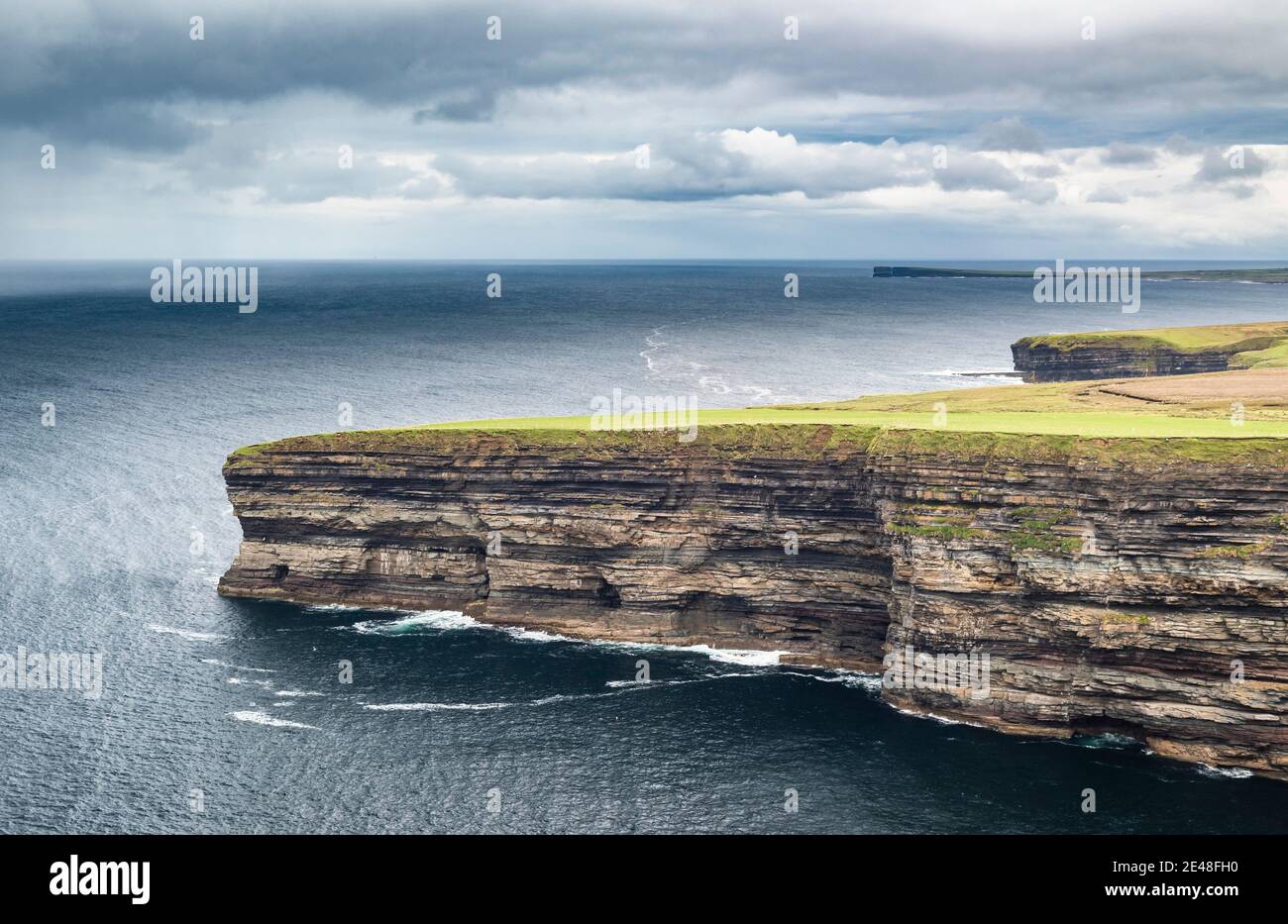 Cliffs of interbedded Lower Carboniferous limestones and shales protruding into the Atlantic Ocean near Downpatrick Head, north Mayo, Ireland Stock Photo