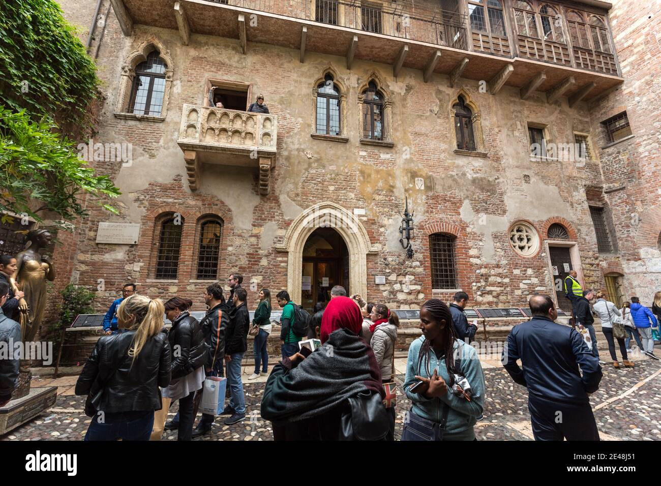 Tourists below the balcony in the Casa di Giulietta (Juliet's House), Via Cappello, Verona, Italy Stock Photo