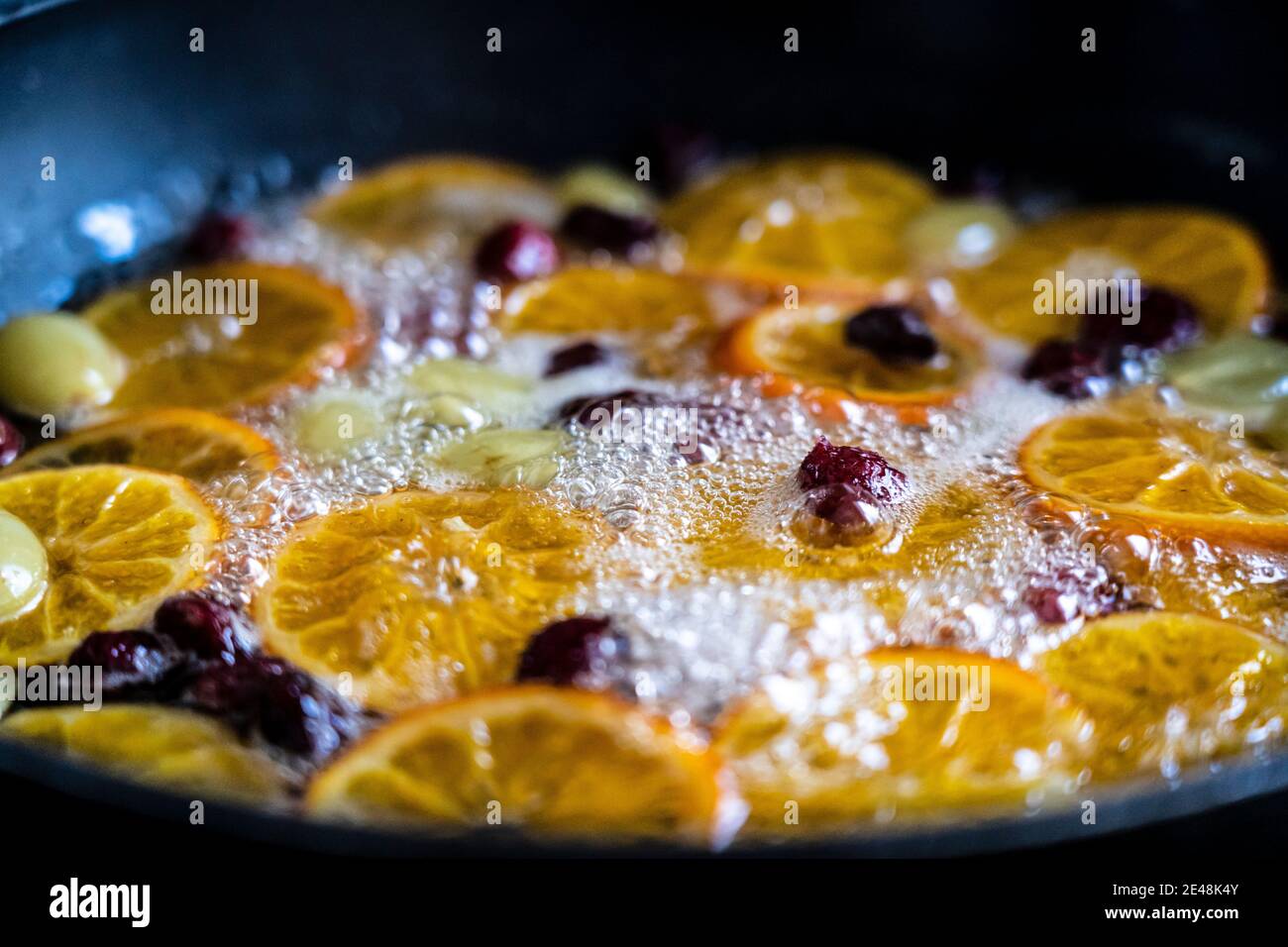 candied fruit in a pan to make a dessert mandarin orange grape and