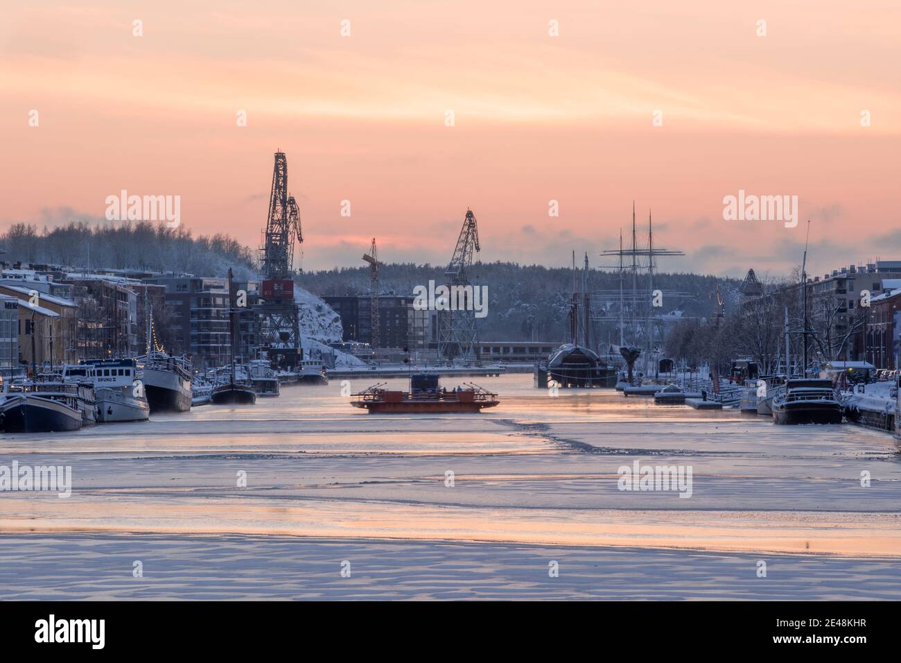 TURKU, FINLAND - Föri ferry on frozen Aurajoki river during sunset. Stock Photo
