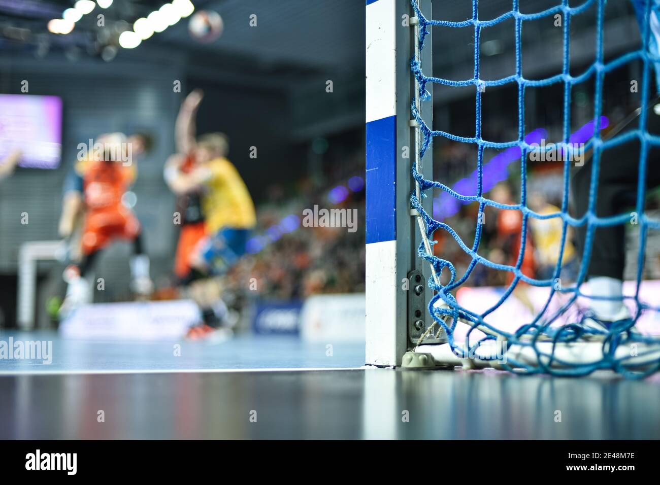 Detail of handball goal post with net and handball match in the
