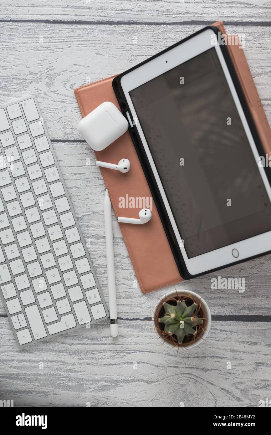 vertical tabletop shot of a white bluetooth keyboard, working home office at a tablet computer Stock Photo