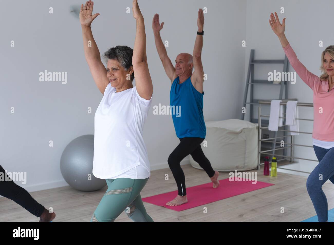 Diverse group of seniors taking part in fitness class at home Stock Photo