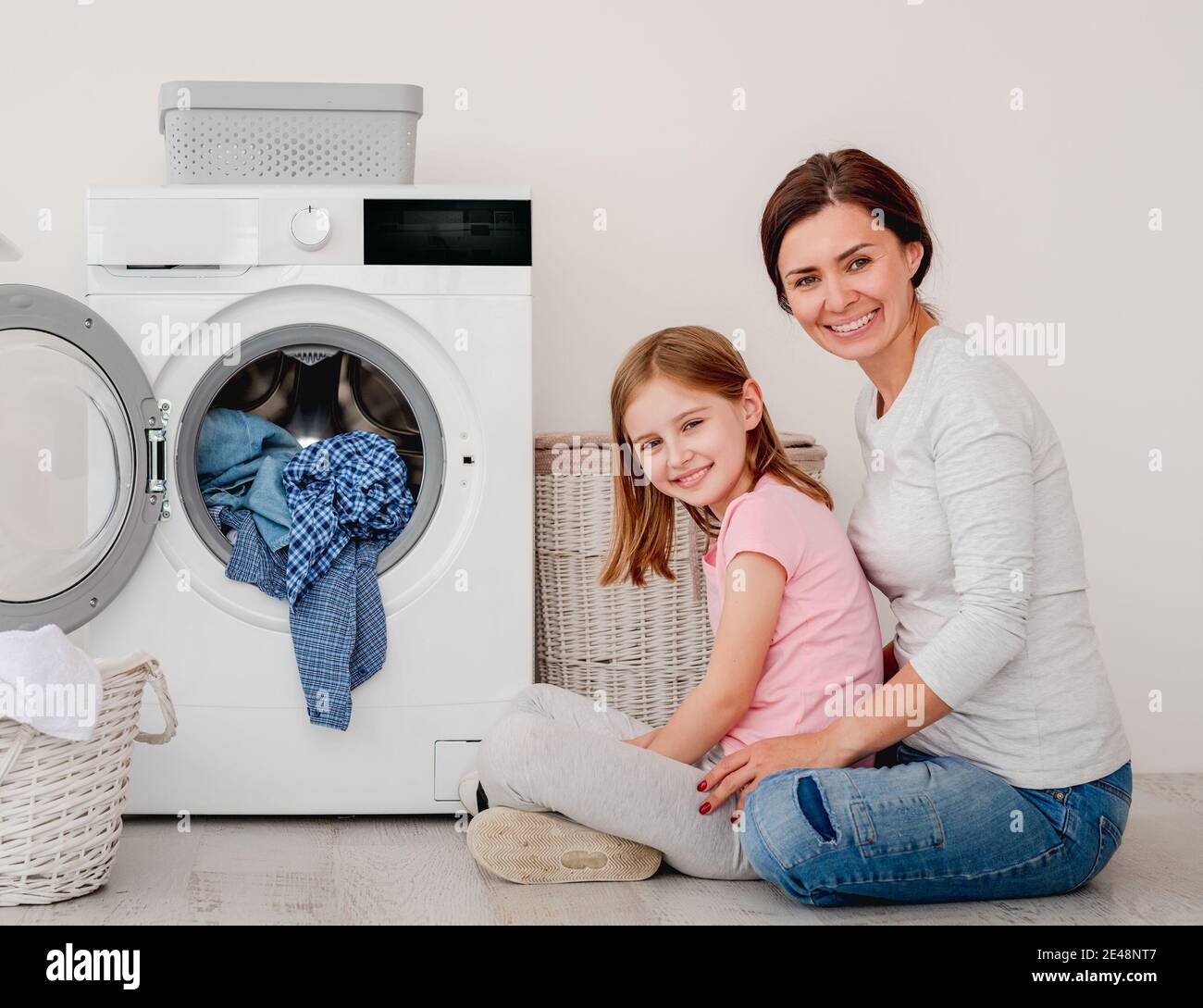 Happy mother and little daughter washing clothes Stock Photo