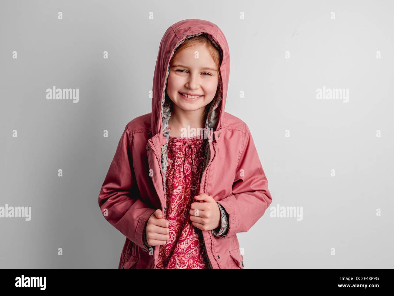Little girl in pink jacket standing indoors Stock Photo Alamy