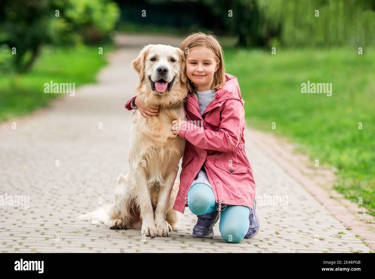 Little girl with golden retriever in park Stock Photo - Alamy