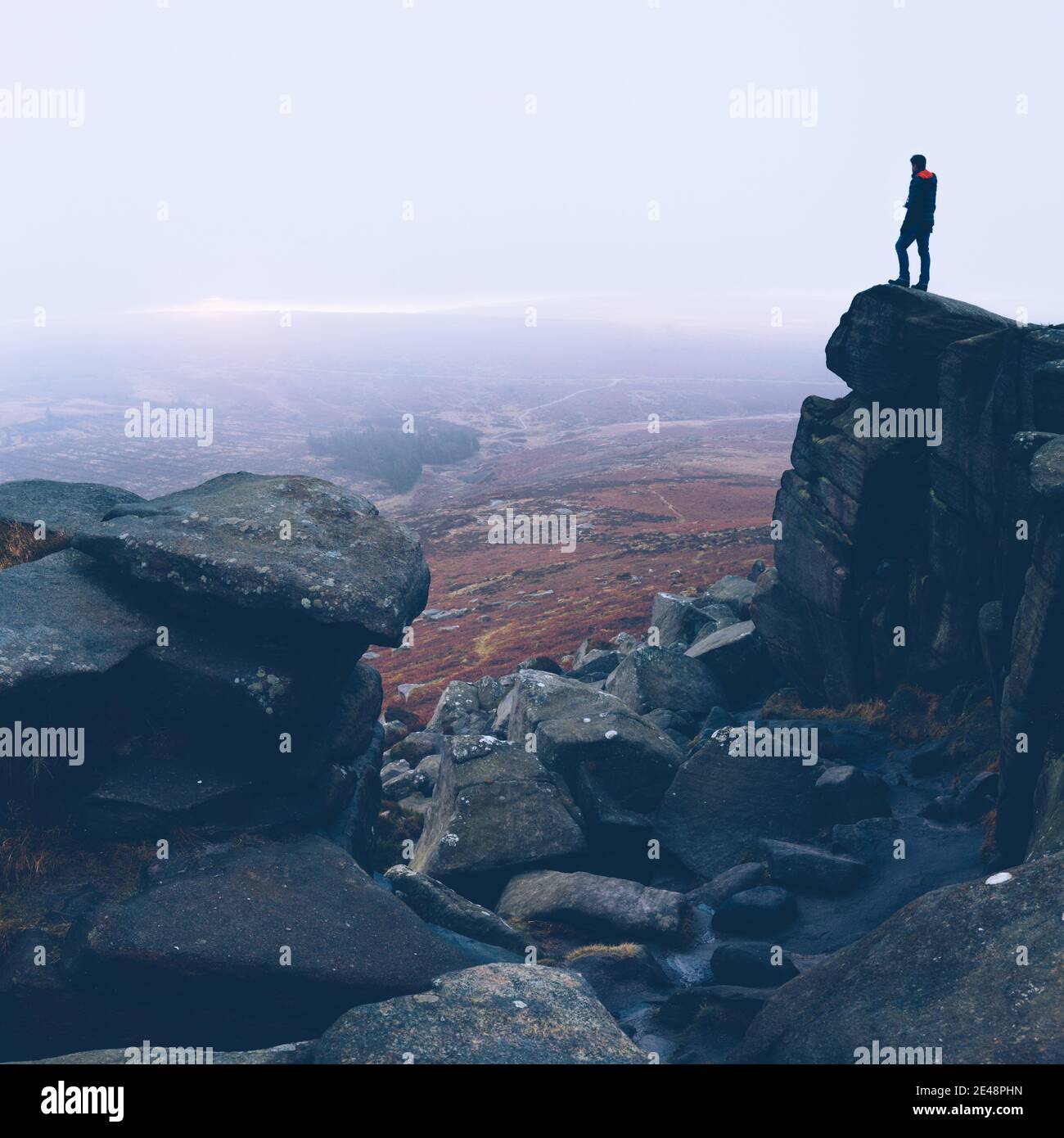 Shot of a man standing on a high rock Stock Photo - Alamy